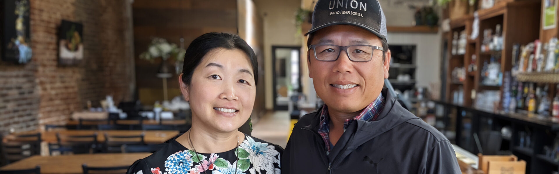 Two people standing in a restaurant.