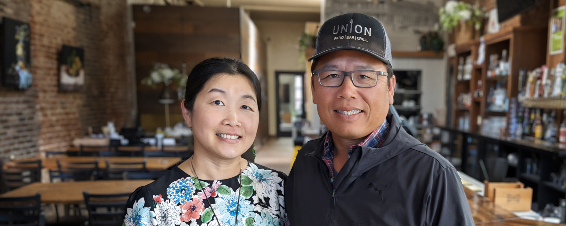 Two people standing in a restaurant.