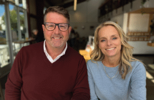 Man and woman sitting next to each other smiling.